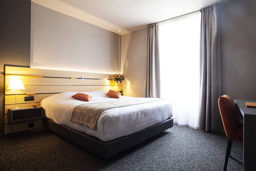 Vue intérieure d'une chambre à l'Hôtel du Morvan avec lit double