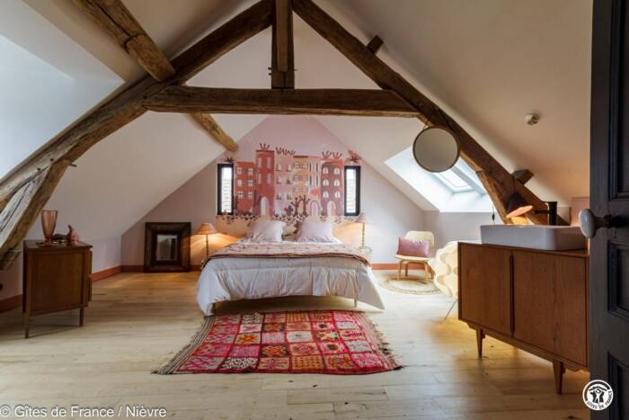 Vue intérieure d'une chambre avec lit double sous les toits.
