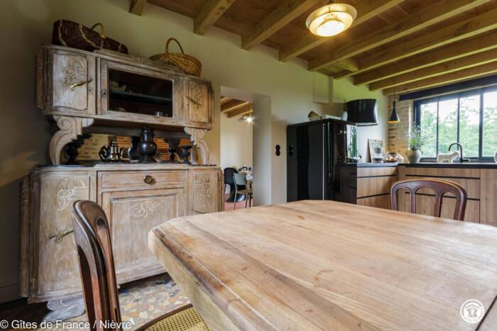 Vue intérieure de la cuisine avec poutres apparentes, meubles ancien et contemporains en bois