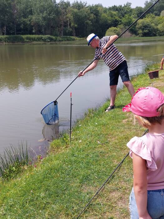 Pêche en No-kill au carpodrome. Un enfant prend des cours avec un pêcheur.