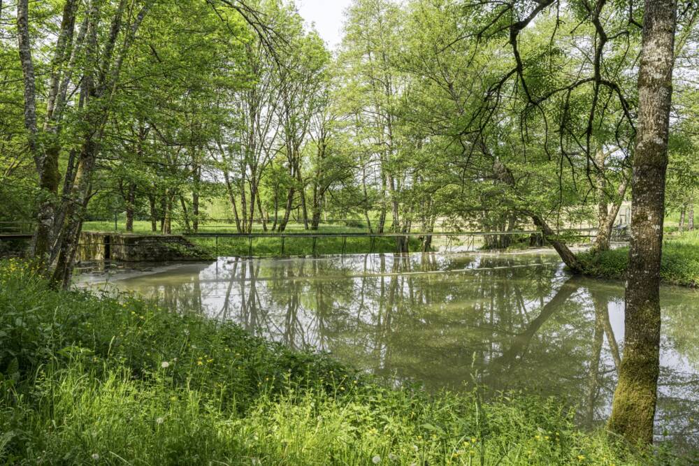 Vue extérieure du site de coeuillon. Passerelle, rivière Aron et bois ombragé.