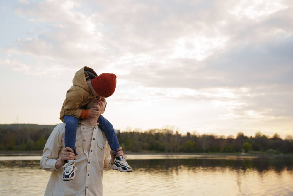 Un père avec son fils sur les épaules se baladent en bord de Loire