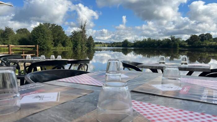 Terrasse extérieure de la Guinguette avec vue sur le plan d'eau du Marnant